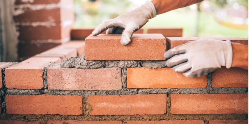 Construction workers laying bricks